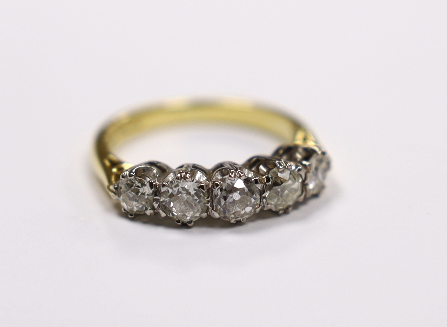 A modern 18ct gold and graduated five stone diamond set half hoop ring, size M, gross weight 4.5 grams.